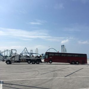 Towing truck hauling a red bus